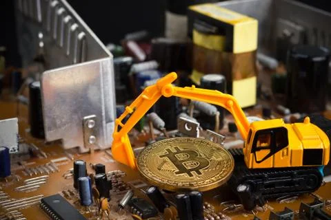 Backhoe dig bitcoin on mainboard. 库存照片