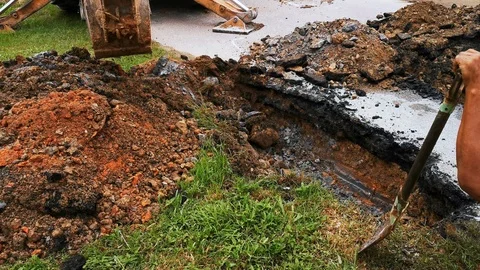 Backhoe digging leaking water pipes Video stock 118955361