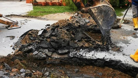 Backhoe digging leaking water pipes Stock Footage 118956146