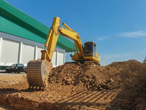 Backhoe digging side walk way for landscape in middle day. Stock Photos