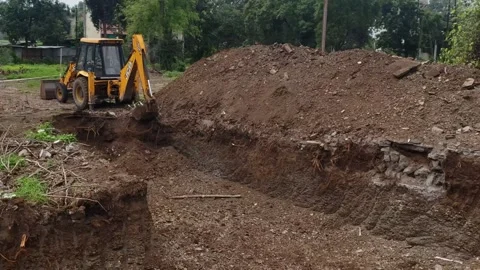 Backhoe digging up the soil to prepare a... | Stock Video | Pond5