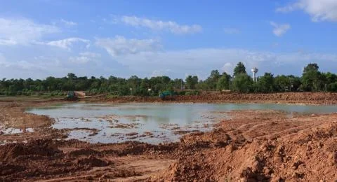 Backhoe dredging the pond to store water for public use in the dry season.Mah Stock Photos