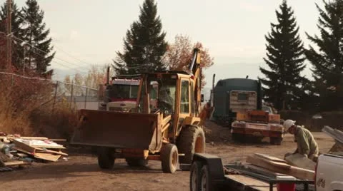 Backhoe driving with dump truck Stock Footage 21563474