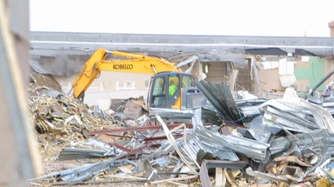 Backhoe drops metal scraps in pile at demolition site A Stock Footage 125054953