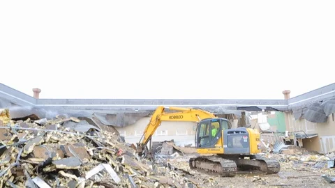Backhoe drops metal scraps in pile at demolition site E Video stock 125055005