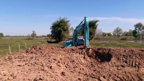 Backhoe dug a pond to store water for use during the dry season. Stock Footage 84961791