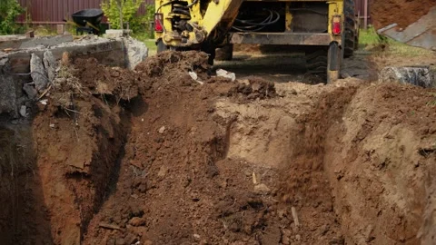 Backhoe excavator digging foundation trench on construction site Stock Footage 341294513