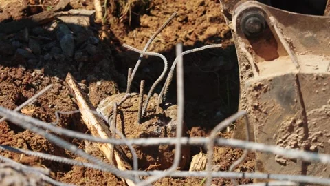 Backhoe Loader Bucket Moving Soil Around Exposed Rebar Stock Footage 337830707