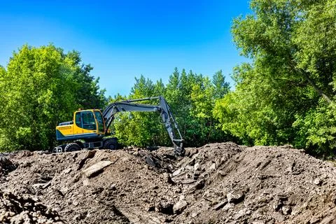 A backhoe loader digs at a construction site Stock Photos