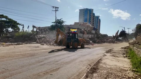 Backhoe loader moving earthquake debris with Venezuelan flag in Caraballeda La Stock Footage 340919902