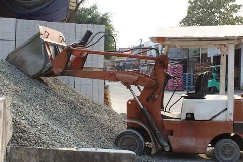 Backhoe loader or excavator loader is transporting crushed stone Stock Photos