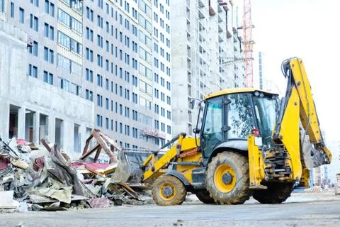 Backhoe loader removes debris on construction site Stock Photos