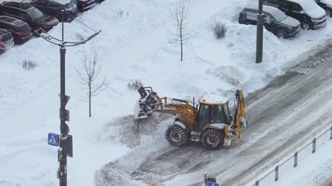 Backhoe loader tractor clearing snow from city street Stock Footage 328251736