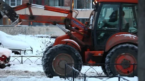 Backhoe loader turn back and drive against snowy roadside and apartment building 動画素材 65724806
