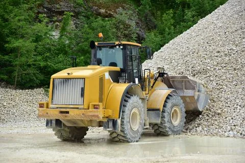 A backhoe loader with wheels is standing in a quarry Stock Photos
