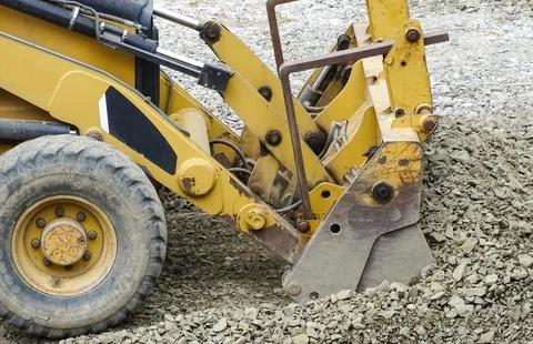 A backhoe loader works with a pile of stone 库存照片