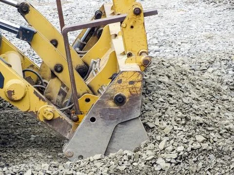 A backhoe loader works with a pile of stone Foto stock