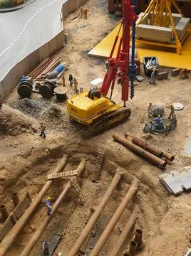 Backhoe loader in yellow removing rock, car toy for kids play around outside, Stock Photos