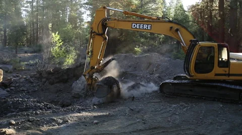 Backhoe moving rock and dirt in forest Stock Footage 51598064