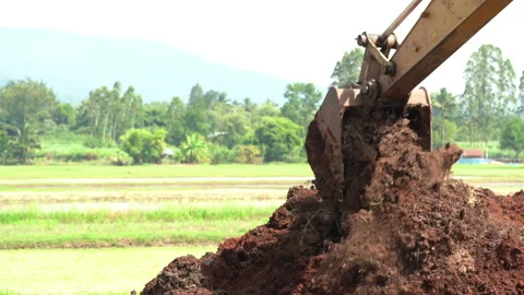 Backhoe or excavator working on land of countryside, excavator dig soil in field 動画素材 158492987