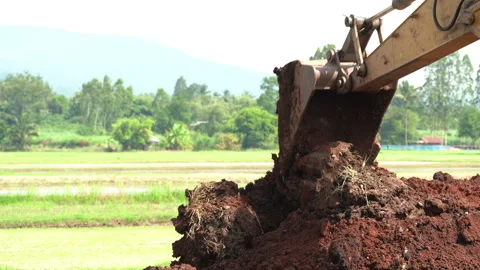 Backhoe or excavator working on land of countryside, excavator dig soil in field Vidéo 158493442