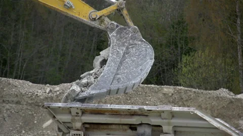 A backhoe slowly dropping off rocks Stock Footage 38916290