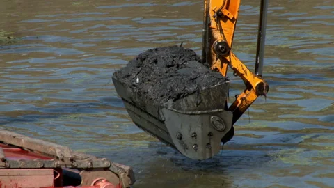 Backhoe takes a scoop of sludge, of dredging activities for canal maintenance. Video stock 137068360