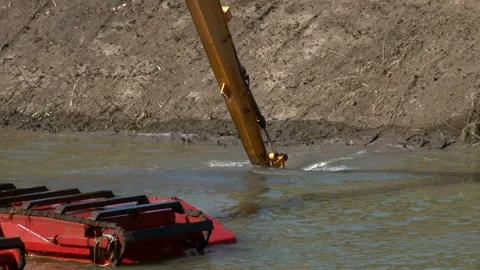 Backhoe takes a scoop of sludge, of dredging activities for canal maintenance. Video stock 137068585