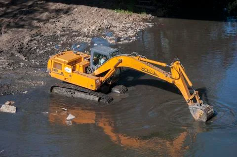 Backhoe working in the River Bernesga Stock Photos