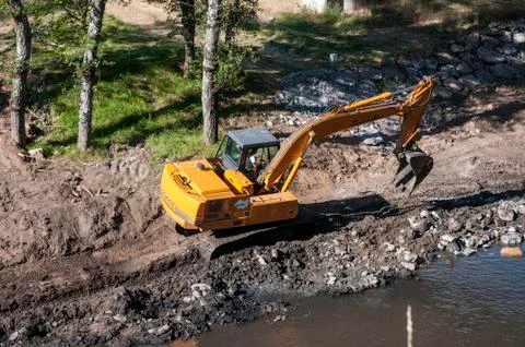 Backhoe working in the River Bernesga Stock Photos