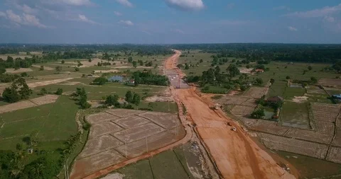 Backing up above forest in field past building construction road in sunset Stock Footage 109077537