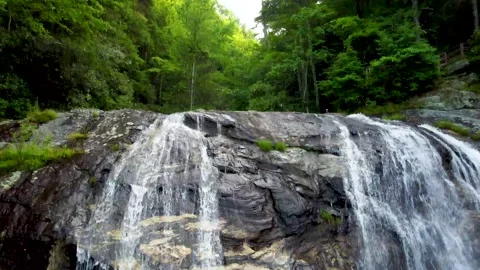 Backing away and tilting up from waterfall ledge Stock Footage 158324541
