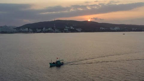 Backing up away from floating boat and island in the ocean early in the dusk bef Stock Footage 124106517