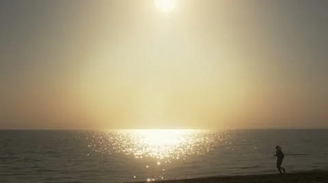 Backlight on the beach with jogger Video stock 39593996