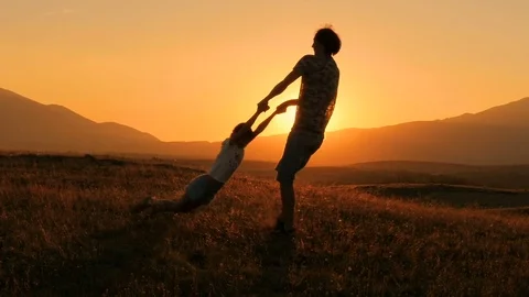 Backlight. Beautiful sunset. A happy child. A father plays with his son. Stock Footage 79107840
