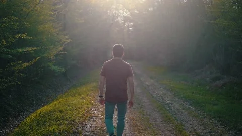 Backlight Isolated young man walking toward the light 動画素材 132346412