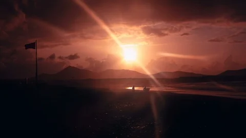 Backlight shot of surfers walking towards the water on Famara beach in Lanzarote Stock Footage 89144371