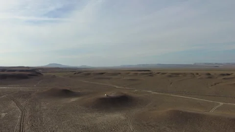 Backlit aerial view of the empty steppe with low mounds near Sherkala 库存影片 348763127