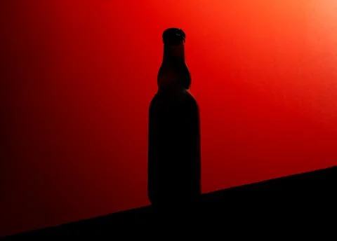 Backlit beer bottle mockup on red background Stock Photos