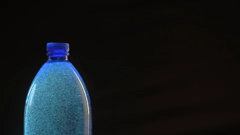 Backlit blue plastic bottle of still natural water with gas bubbles. Backlit, Видео 91676857