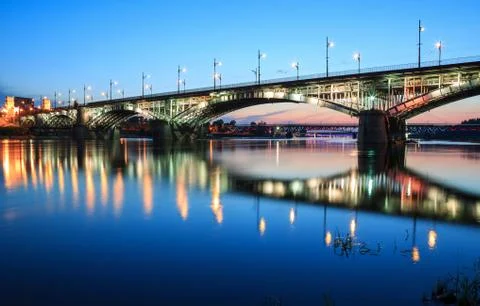 Backlit bridge at night and reflected in the water Stock Photos