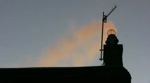 Backlit chimney smoke over the rooftop Stock Footage 20432067