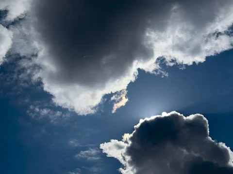 Backlit clouds in a deep blue sky. Bright sun rays outline the cloudscape. Photos