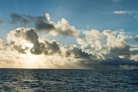 Backlit clouds over a tranquil ocean Stock Photos