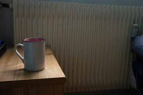 Backlit coffee cup standing on bedside table Stock Photos