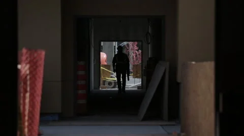 Backlit Construction worker walking in a tunnel Stock Footage 63917030