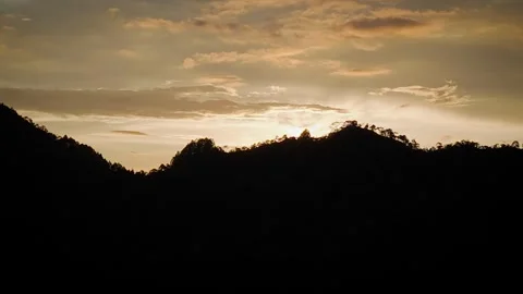 Backlit Descent Beneath Ridge as Sun Rises Beyond Stock Footage 316796441