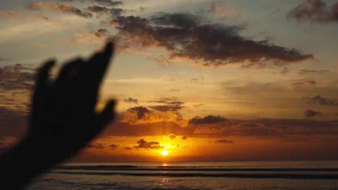 Backlit Hand Gestures In Foreground Against Glowing Bali Ocean Sunset, Layered Vídeos de archivo 347677504