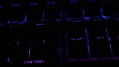 Backlit keyboard at home. Colored light. Mechanical keyboard. Working office. Video stock 129810474