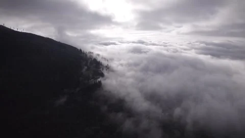 Backlit Mountain shrouded in clouds Stock Footage 253831102